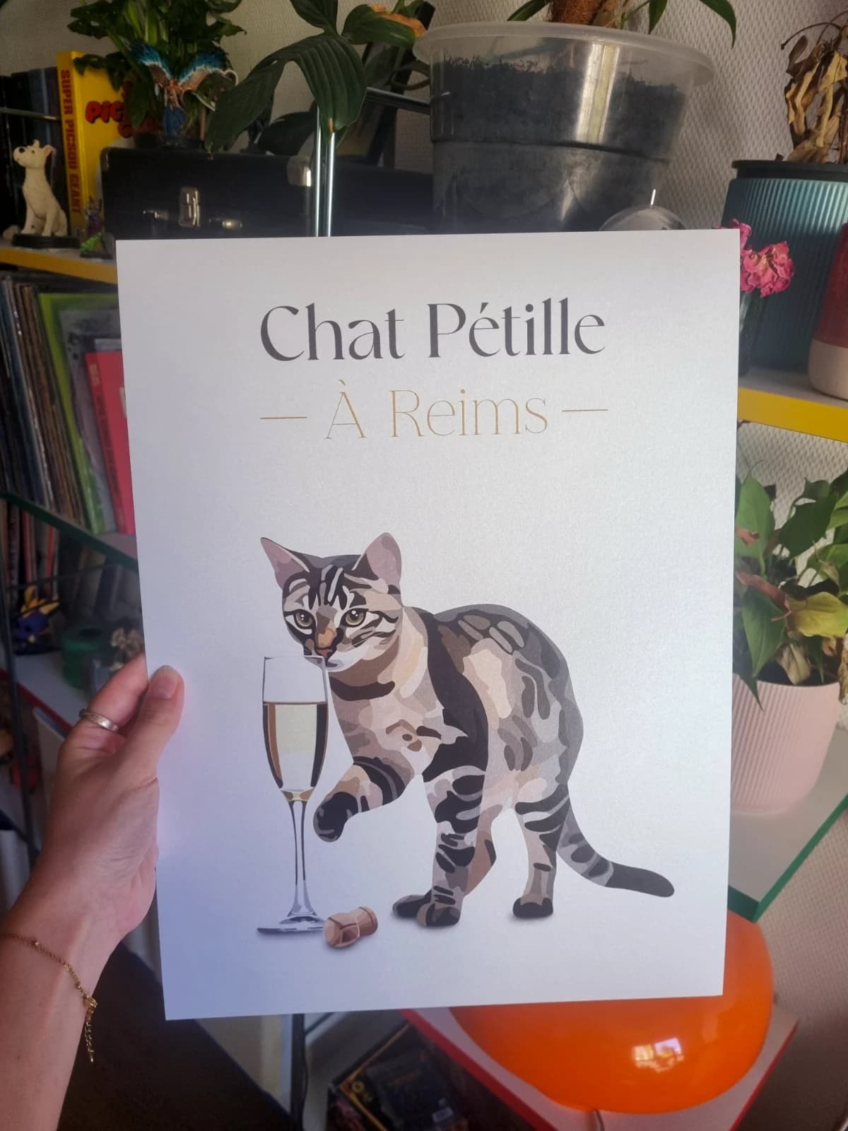 Affiche blanche illustrée d'un chat tigré près d'une flûte et du texte Chat Pétille À Reims.